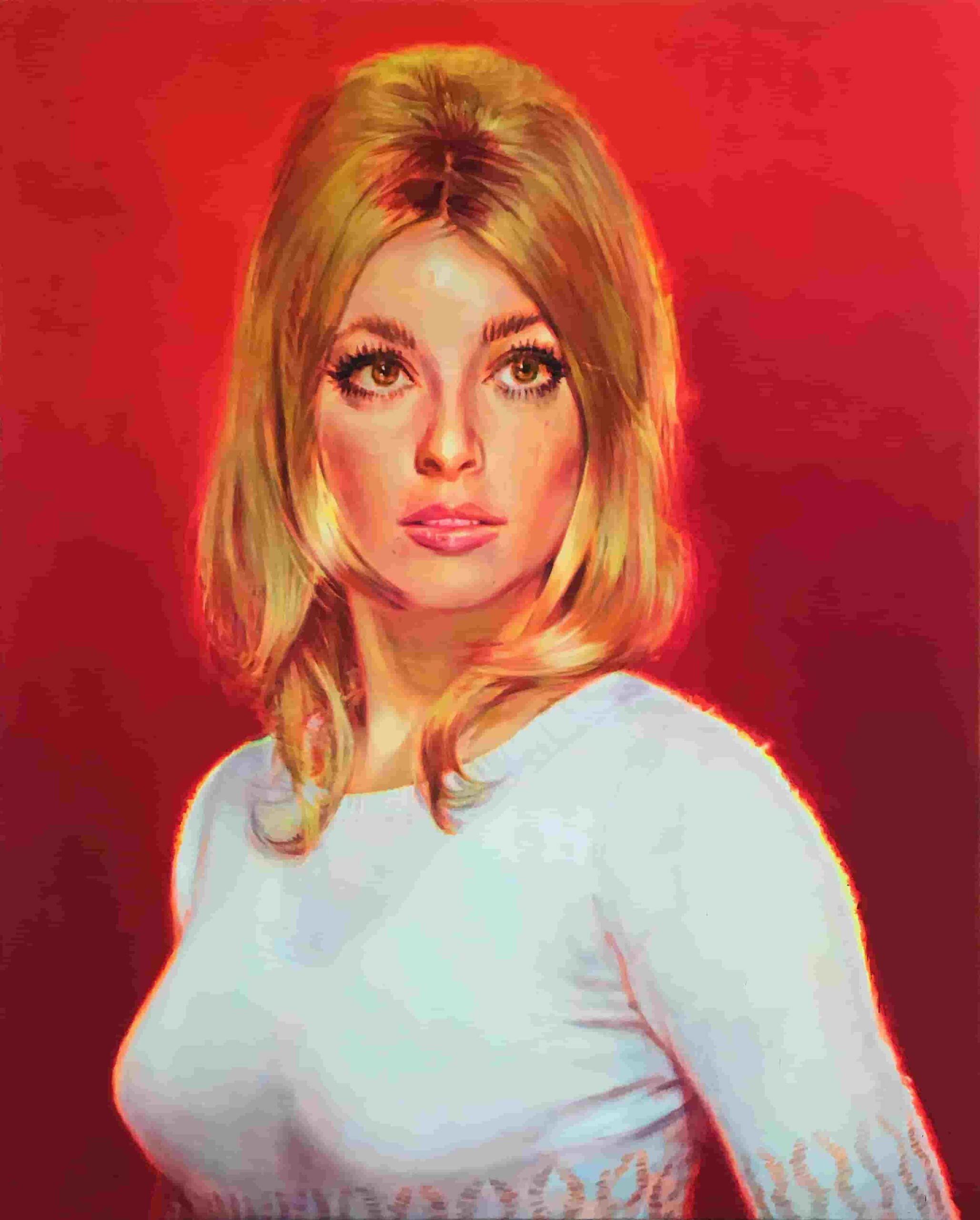 Portrait d'une femme blonde portant un pull blanc sur fond rouge.