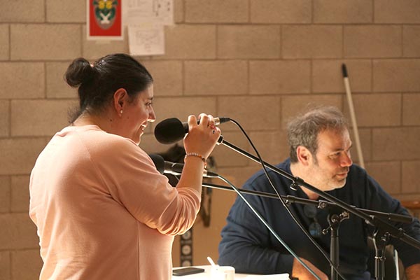 Une femme est devant un micro pour enregistrer sa voix.