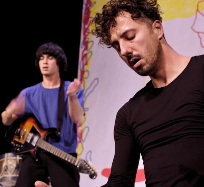 Le danseur et chorégraphe Laurent Cebe en gros plan et le musicien Jonathan Poulet avec sa guitare électrique en arrière plan.