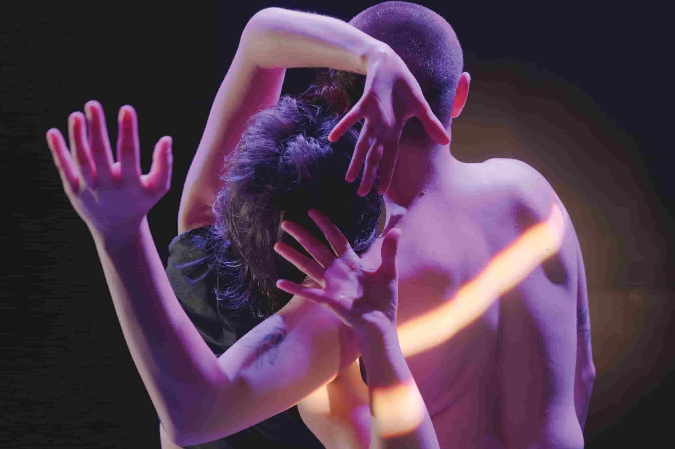 Cadrage serré sur le haut du corps de deux interprètes, de dos.