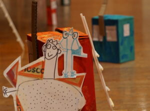 Figurines de papier et maison de carton créées au cours d'un atelier.